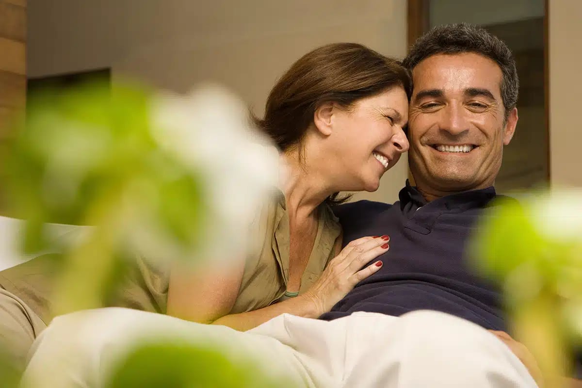 Happy couple in the couch laughing