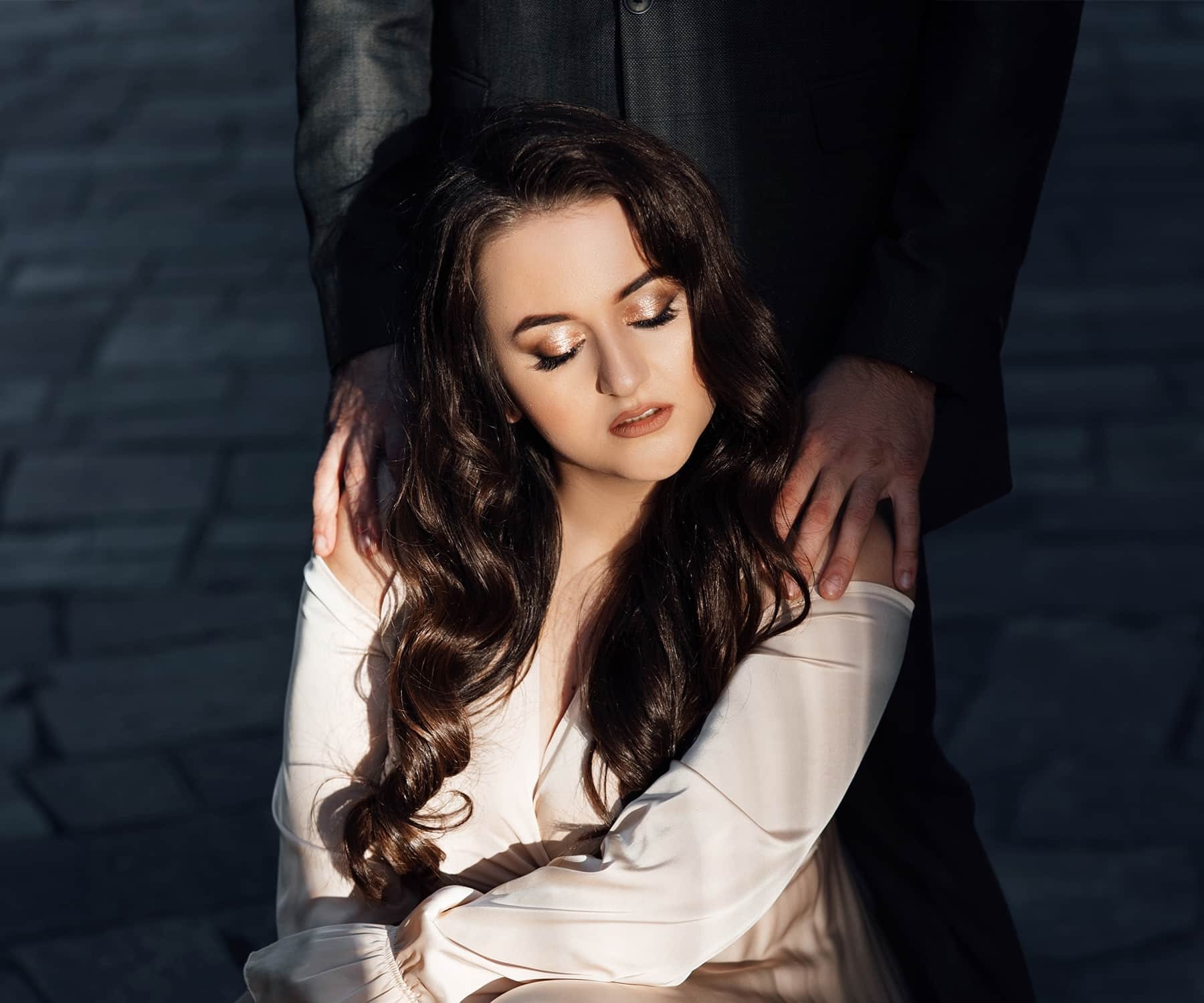 young woman with man standing behind her young woman with man standing behind her