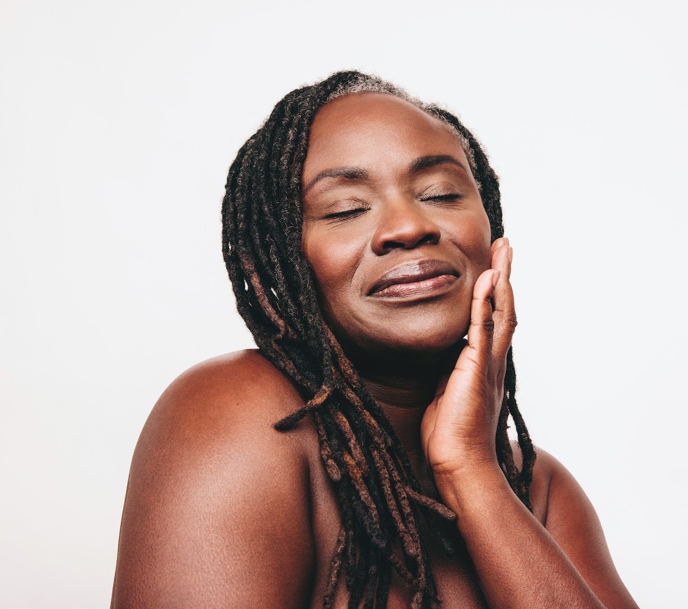Beautiful black woman touching her flawless skin beautiful mature woman with natural makeup