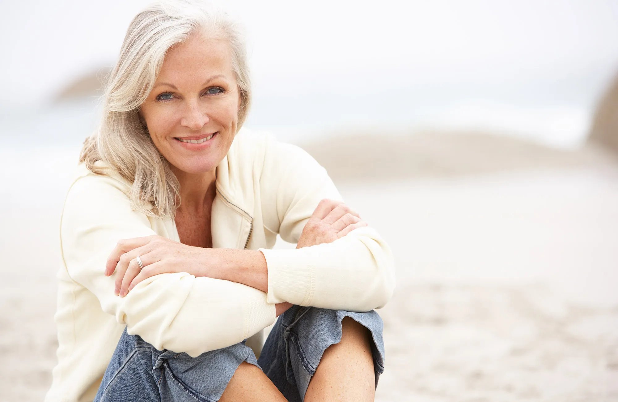 beautiful happy senior woman sitting at beach