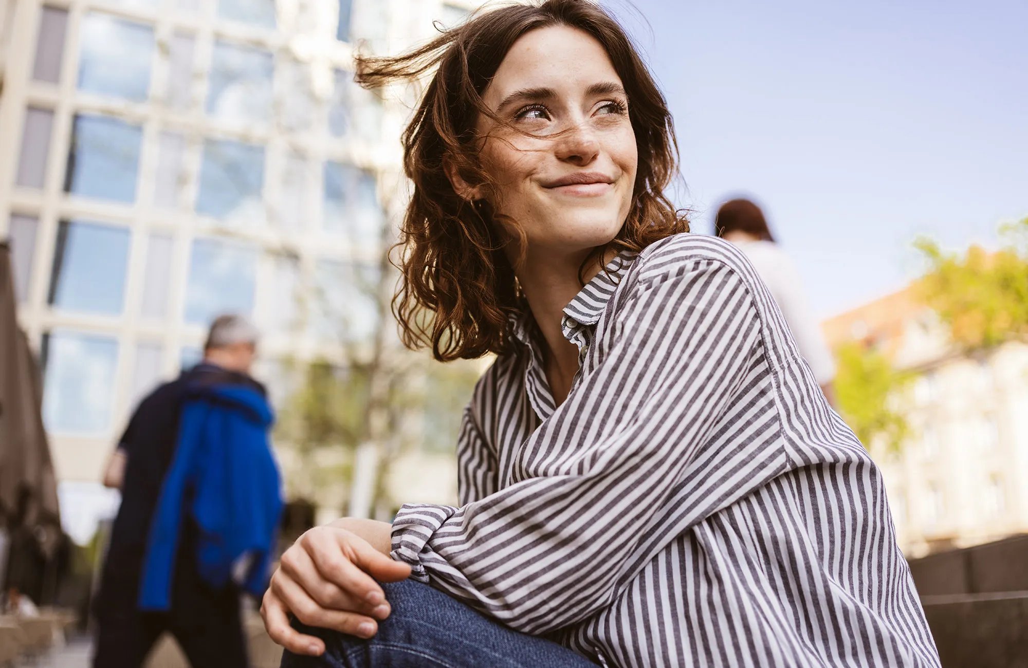 Reviv 1 happy smiling young woman sitting in city