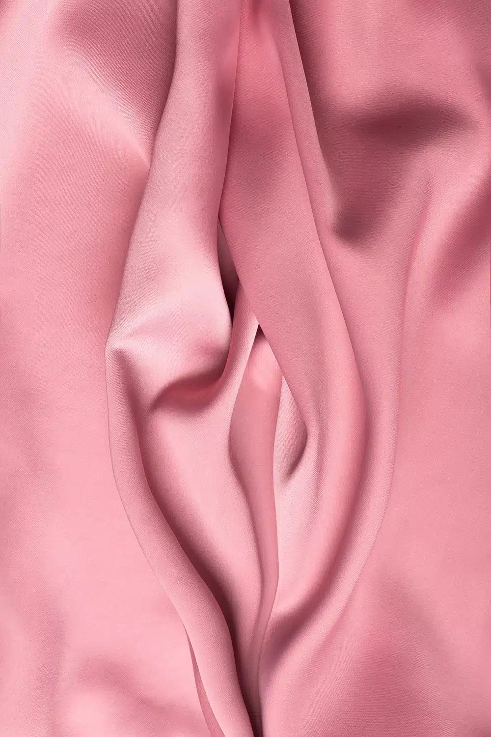 Draped pink fabric with soft folds and creases.